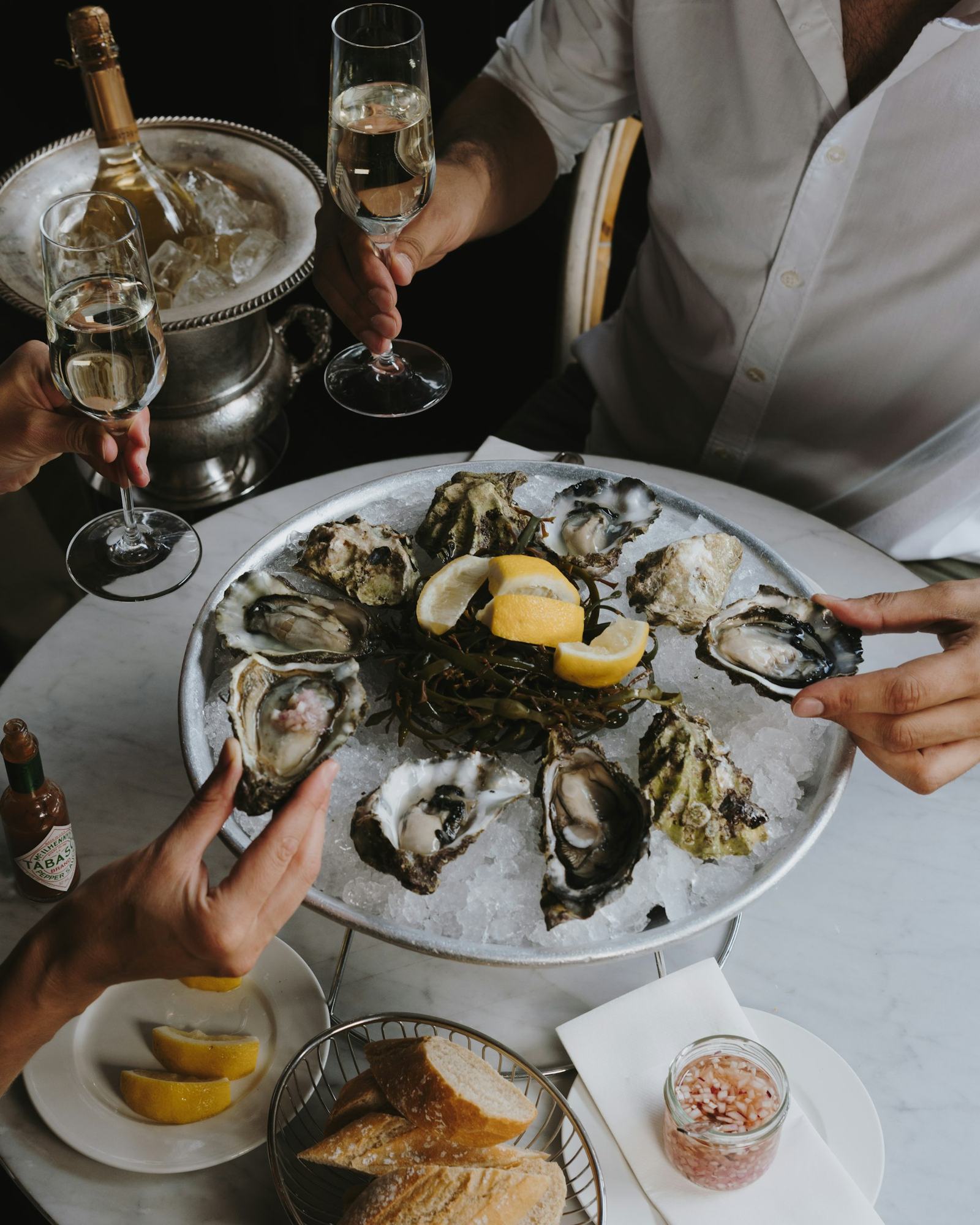Friends sharing oysters and sparkling wine